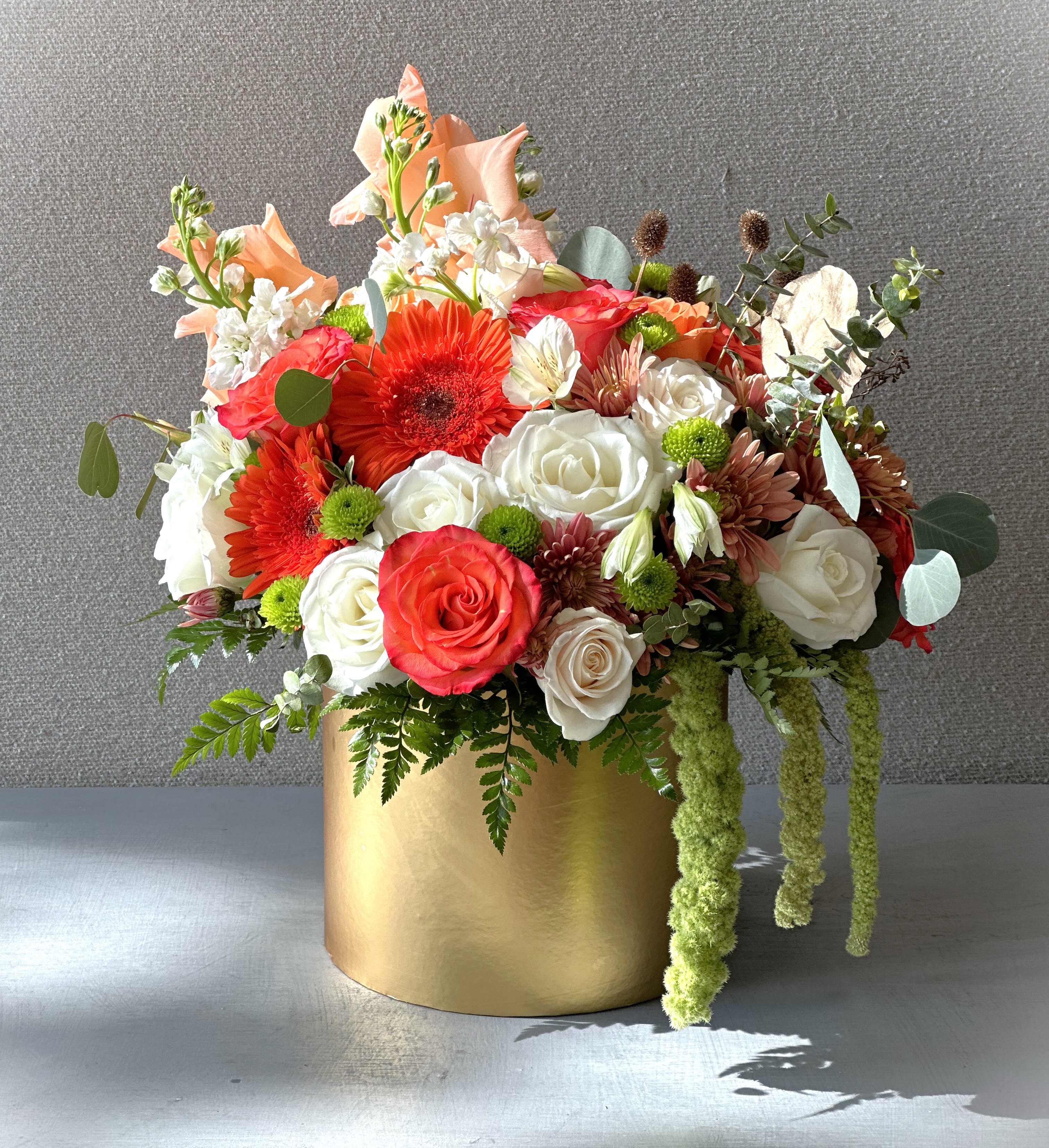 White, creme and orange roses, gerbera daisies with some touches of gold